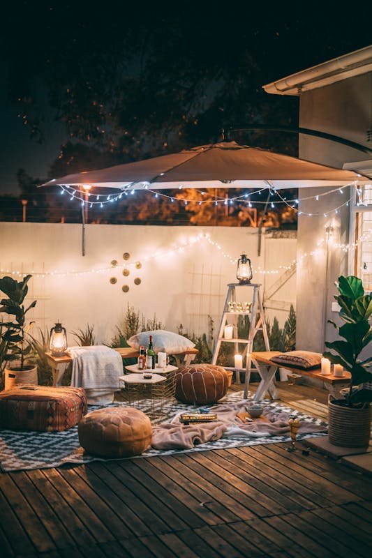 Charming outdoor cozy patio patio scene with cozy seating and warm lighting at night.