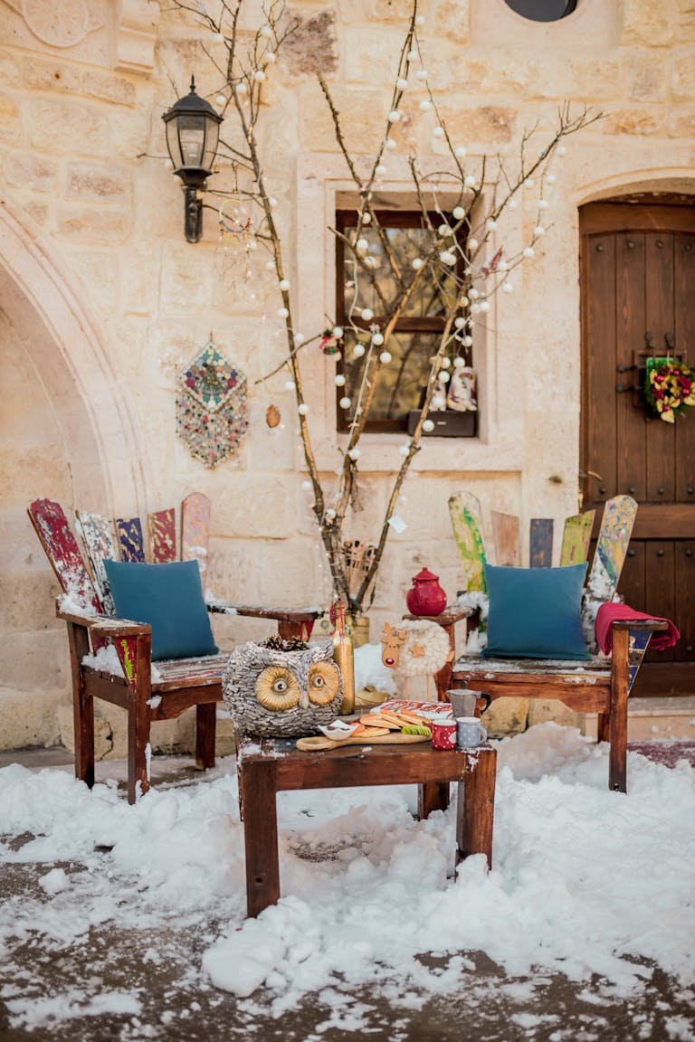 Charming outdoor winter scene with rustic furniture and decor in snowy Ürgüp, Türkiye.