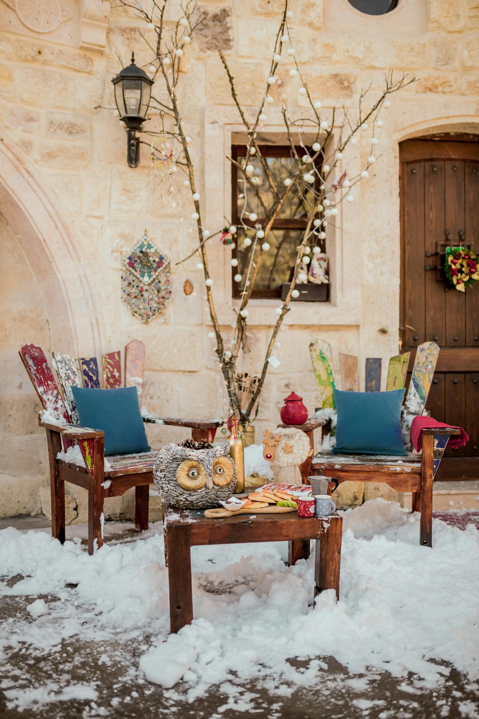 Charming outdoor winter scene with rustic furniture and decor in snowy Ürgüp, Türkiye.