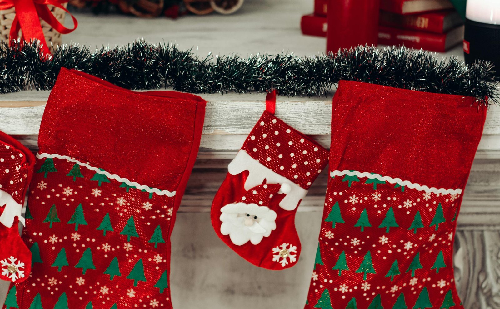 Colorful Christmas stockings hanging on a decorated mantlepiece.