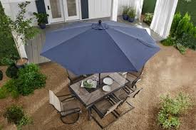 drone shot of a patio umbrella with table and chairs underneath
